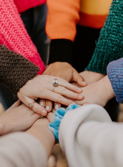 IWCE Monthly Meetings - Women's hands together in a circle - Photo by Hannah Busing on Unsplash