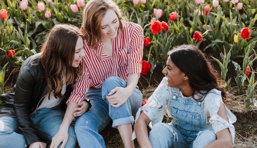 IWCE Becoming a member - Three women sitting and laughing outside among tulips  - Photo by Priscilla Du Preez on Unsplash